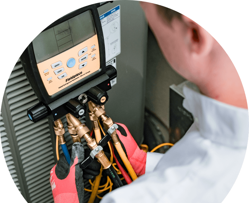 A Shines home service crew member uses a digital manifold gauge to check refrigerant levels on an HVAC unit for service. A Shines home service crew member uses a digital manifold gauge to check refrigerant levels on an HVAC unit for service.